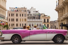 Typische Straßenszene in Havanna - ein Oldtimer mit Taxifahrer und Touristen .